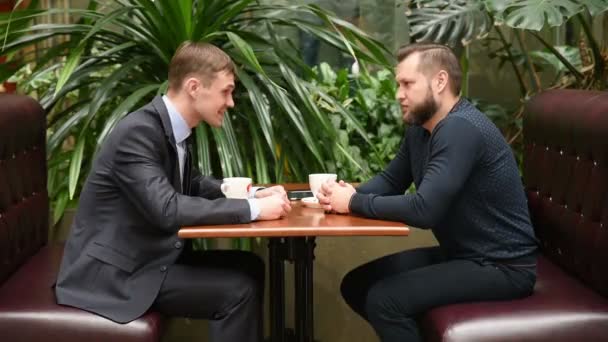 Diskussion in einem Café von zwei Geschäftsleuten — Stockvideo