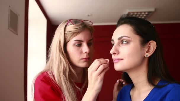 Backstage scene: professionele make-up kunstenaar doet glamour model make-up op het werk — Stockvideo