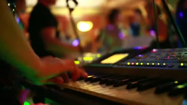 Дівчина грає на синтезаторі в клубі. люди танцюють — стокове відео