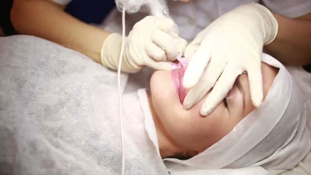 Schöne junge Mädchen, die sich tätowieren lassen. Tätowierer macht Permanent Make-up — Stockvideo