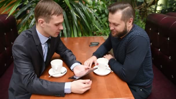 Dos hombres en un café usando un Tablet PC. malestar — Vídeo de stock