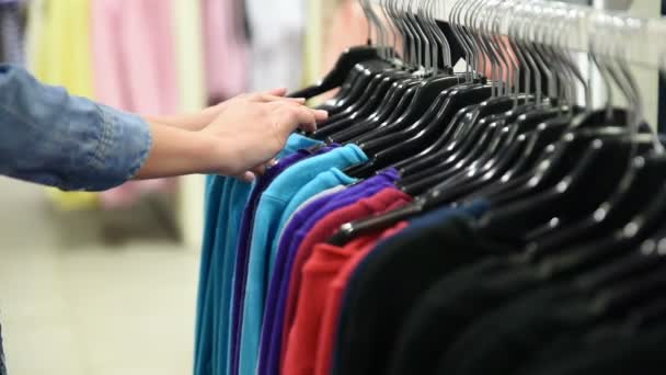 Kobieta klient szuka T-shirty w sklepie mody — Wideo stockowe