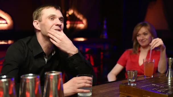 Cheerful man sitting at the bar. drinking alcohol from a stack. — Stock Video