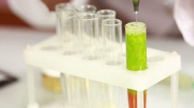 Kadın kimyacı test tüpleri kimyasallar ile karşılaştırma. koruyucu gözlük