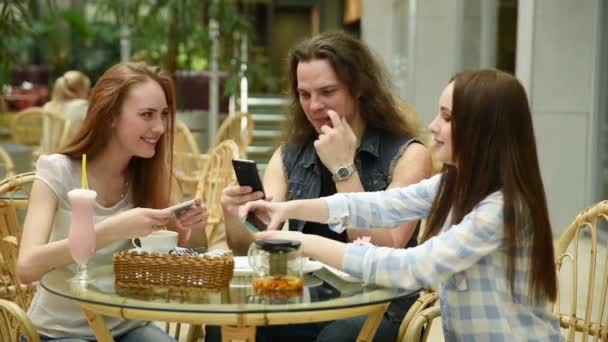 Technologie, Lifestyle- und People-Konzept - glückliche Freunde mit Smartphones beim Essen im Restaurant — Stockvideo