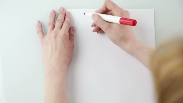 Woman writes on a sheet of paper plan — Stock Video