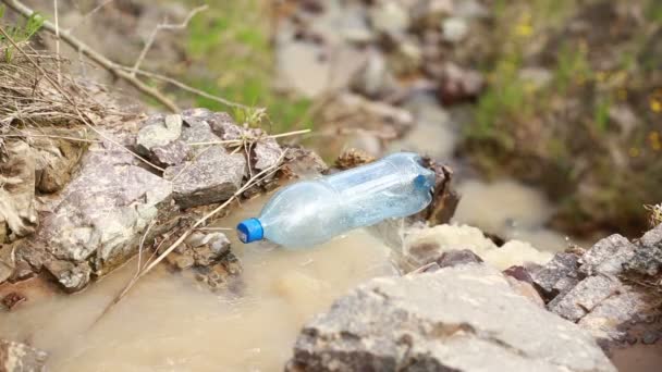 Брошенная бутылка плавает в реке — стоковое видео