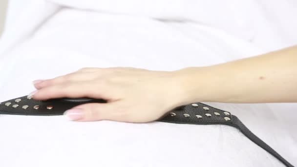 Vrouwelijke hand neemt fetish masker. speelgoed van het geslacht. witte lakens — Stockvideo