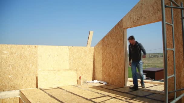 Un hombre construyendo una casa. espuma de poliestireno. bloques de madera contrachapada y aislamiento. casa de limpieza — Vídeos de Stock