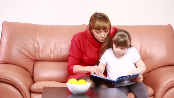 Mother and Downs Syndrome girl reading — Stock Video
