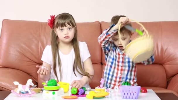 Niños jugando en el sofá. chica con síndrome de Down. rehabilitación de los minusválidos — Vídeo de stock