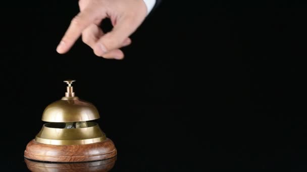 Hand ringing in service bell on wooden table on black background — Stock Video