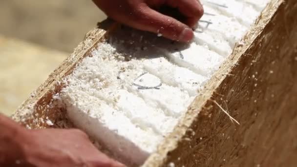 Sawdust fills the air as a carpenter uses a electric powered circular saw to cut a sheet of plywood at a construction site. chain Saw — Stock Video