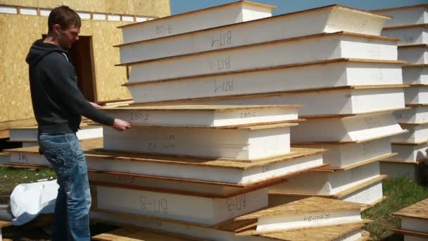 Een man die bouwen van een huis. polystyreen schuim. blokken gemaakt van multiplex en isolatie. huishouding vakantiehuis. meting tape — Stockvideo