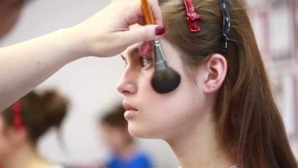 Usando escova de blush para aplicar blush nas bochechas artista de maquiagem profissional trabalhando. salão de beleza — Vídeo de Stock