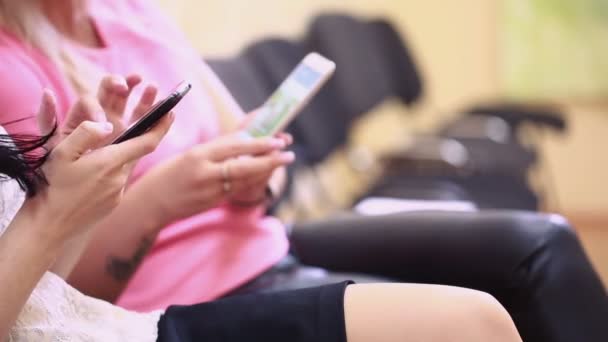 Mujer leyendo correo electrónico en el teléfono móvil. chica sentada en una silla y sosteniendo un teléfono — Vídeo de stock