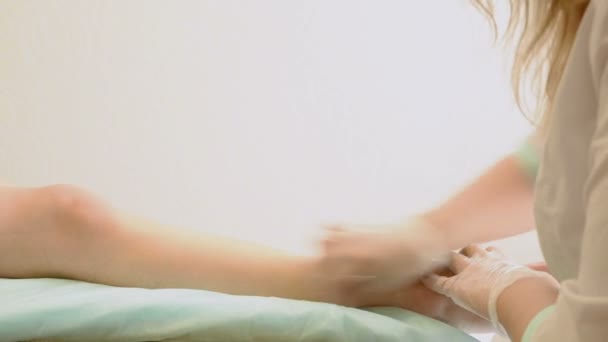 Closeup της γυναικείας θεραπευτής αποτρίχωση πόδι τους πελάτες στο beauty spa. αποτρίχωση πόδια — Αρχείο Βίντεο