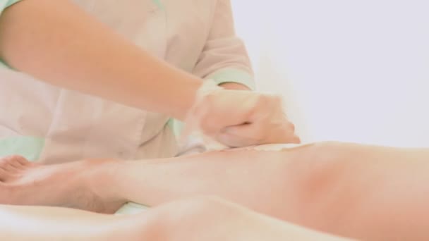 Closeup of female therapist waxing customers leg at beauty spa. depilation legs — Stock Video