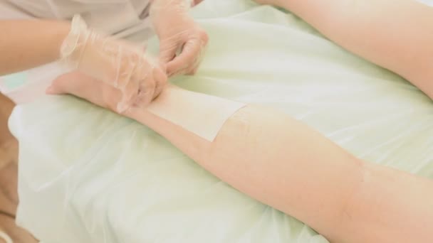 Primer plano de la mujer terapeuta depilación clientes pierna en spa de belleza. piernas de depilación — Vídeos de Stock