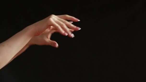 The moving hands of an orchestra conductor directing the musicians. Close-up shot. Black background — Stock Video