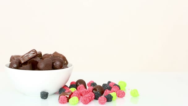 La gente prende i cioccolatini dal piatto. binge eating concept . — Video Stock