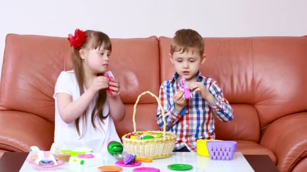 Niños jugando en el sofá. chica con síndrome de Down. rehabilitación de los minusválidos — Vídeo de stock