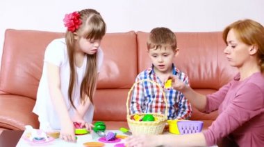 çocuklar kanepede oynuyor. Down sendromu olan kız. Engelli rehabilitasyonu. oynayan çocuklar ile anne