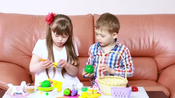 Niños jugando en el sofá. chica con síndrome de Down. rehabilitación de los minusválidos — Vídeos de Stock