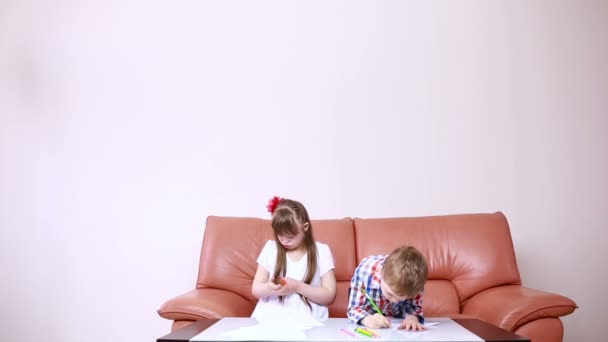 Два очаровательных счастливых ребенка рисуют карандашами в детской школе. девушка с синдромом Дауна. реабилитация инвалидов — стоковое видео