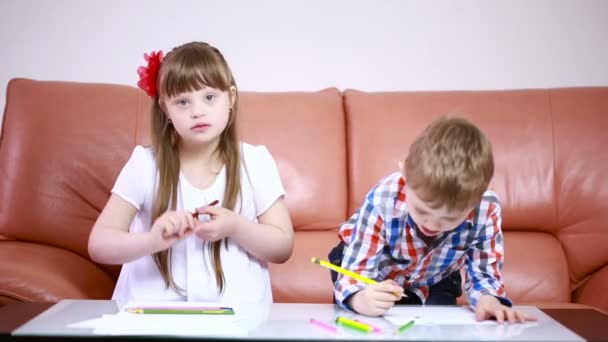Zwei entzückende glückliche Kinder, die im Kindergarten mit Buntstiften zeichnen. Mädchen mit Down Syndrom. Rehabilitation von Behinderten — Stockvideo
