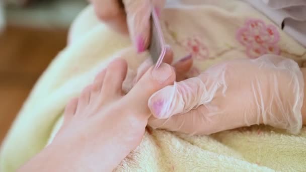 Pedicure nagel technicus werknemer perfoming procedure voor voetverzorging — Stockvideo