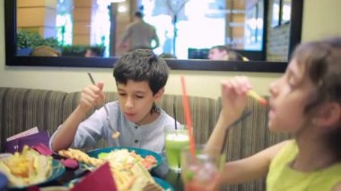 Çocuklar, kardeşim ve kız kardeşi kafede sandviç yeme. patates kızartması