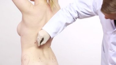 cerrah kadın liposuction cerrahi için hazırlanıyor. Geri