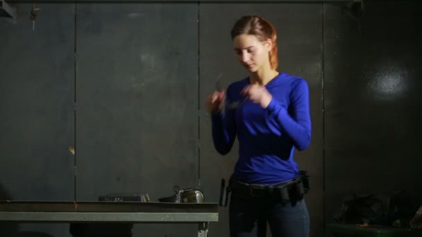 Νεαρή γυναίκα με το όπλο σε ένα εσωτερικό πεδίο βολής. προετοιμασία για τα γυρίσματα — Αρχείο Βίντεο