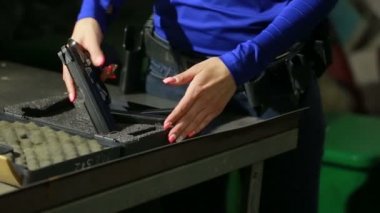 kapalı bir atış poligonuna silahı olan kadın. silah toplamak