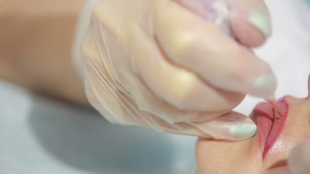 Tatuador profesional haciendo maquillaje permanente. tatuaje labios — Vídeo de stock