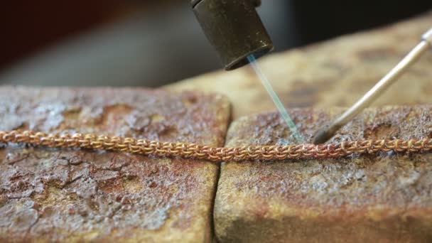 Un joyero detrás de un producto de soldadura de escritorio. reparación de cadena de oro — Vídeos de Stock
