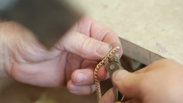 Juwelier hinter einem Löttisch. Goldkette reparieren. Schmuckherstellung — Stockvideo