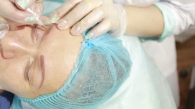 Kozmetik uzmanı kaşlarına kalıcı makyaj uyguluyor.