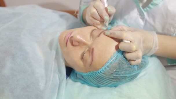 Cosmetólogo aplicando maquillaje permanente en las cejas tatuaje de cejas — Vídeos de Stock