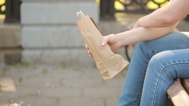 Meisje drinken uit een papieren zak in de straat. anti-sociaal gedrag — Stockvideo