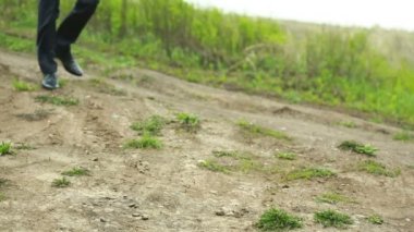 Kirli kırsal yolda yeni siyah deri ayakkabı parlayan erkek ayak standı