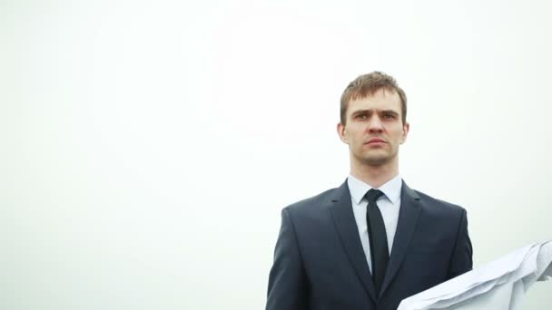 Бізнесмен стоїть зі стопкою паперу на вітрі. кидання документів — стокове відео