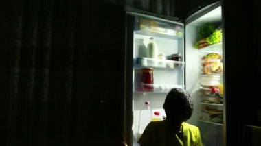 Gece yarısı buzdolabının önünde bir aperatif yemek çocuk.
