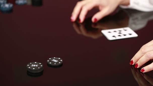 Dealer handling playing cards at a poker table. Black background — Stock Video