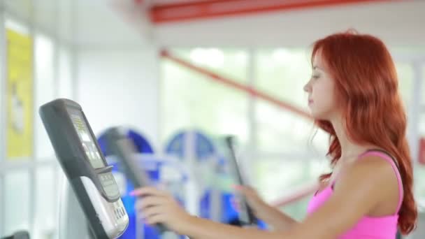 Chica en el gimnasio en simulador. La mujer con piernas atléticas caminando sobre los pasos — Vídeos de Stock