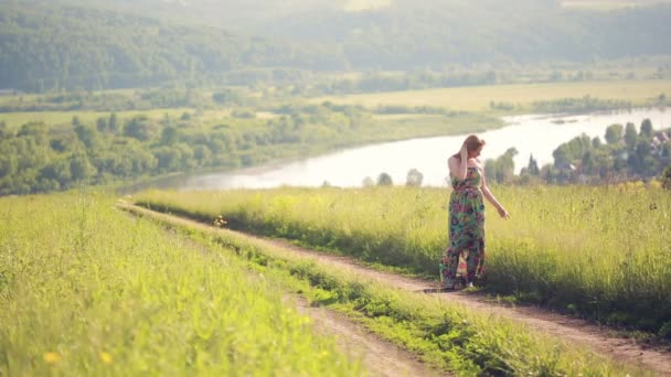 女孩走在一条乡间道路上. — 图库视频影像