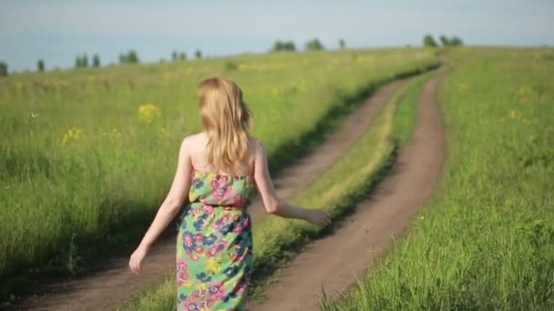 Meisje gaat op een landelijke weg. — Stockvideo