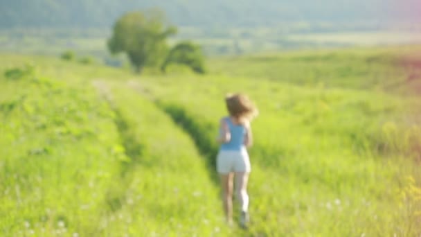 Mujer corriendo. Chica trotando en el sendero en las montañas en el campo con hierba en verano . — Vídeos de Stock