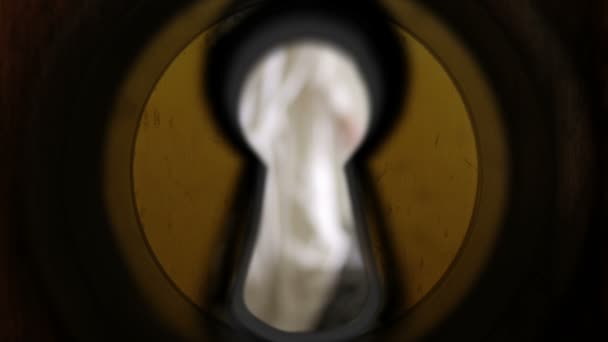 Fata trage cu ochiul prin gaura cheii. femeie neascuțită — Videoclip de stoc